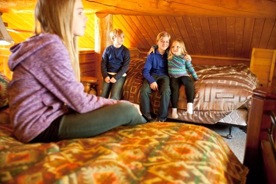 Family relaxing in a cabin loft bedroom